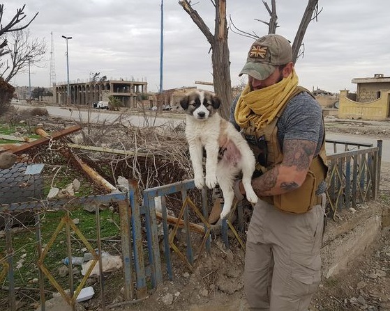 After rescuing a puppy from the debris, the soldier carries his loyal companion in his backpack, ensuring their constant presence and protection. - Puppies Love