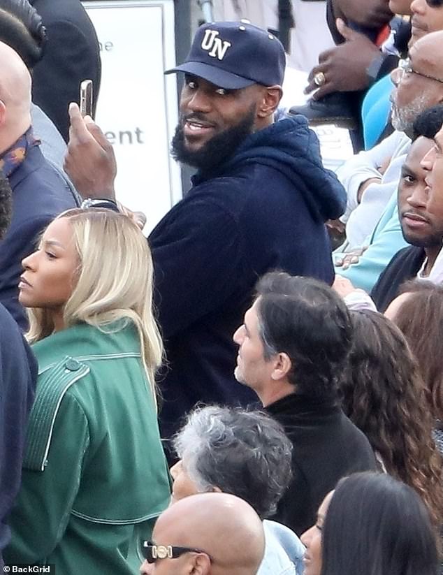 LeBron James plays the role of doting dad as he and wife Savannah watch son Bronny graduate from high school