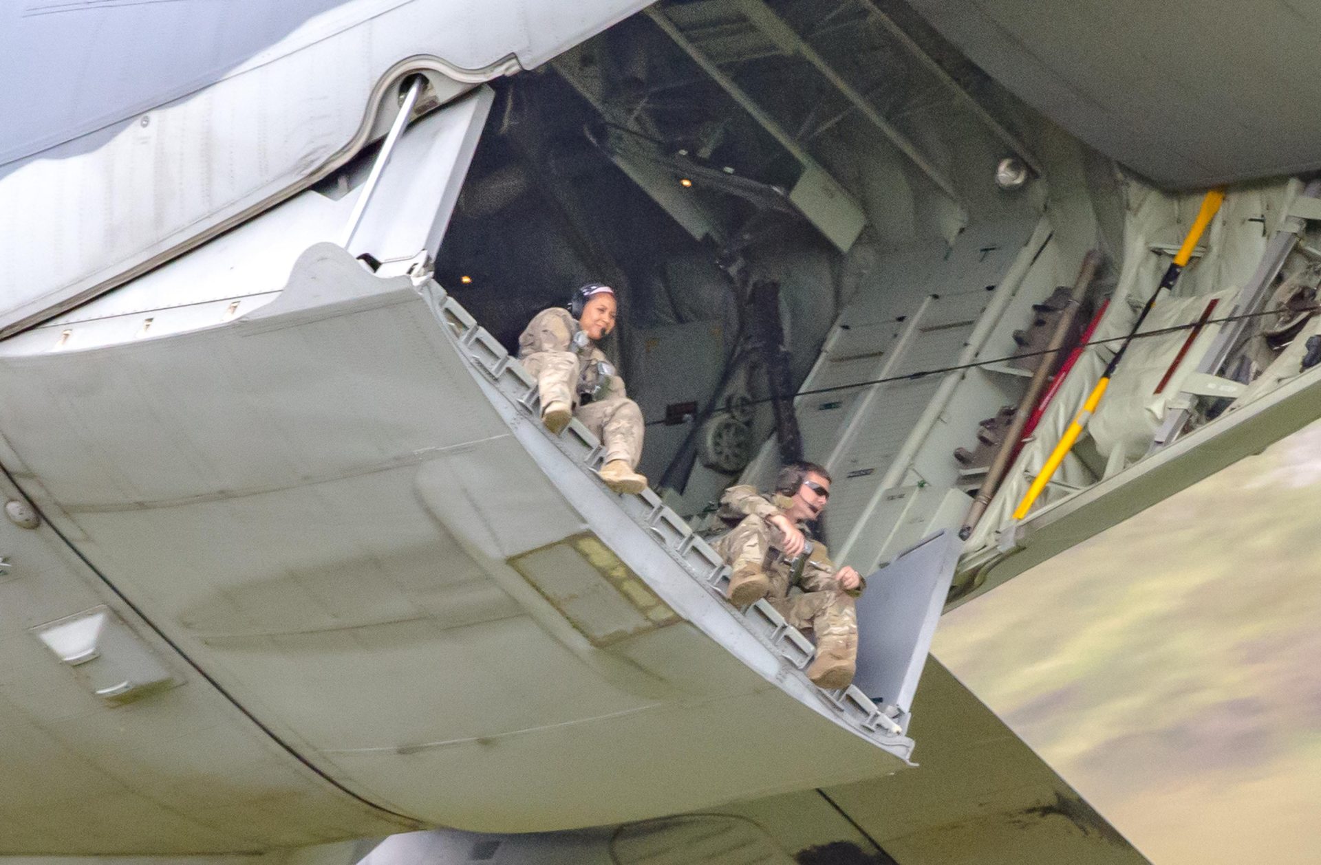 Two US Air Force personnel spotted dangling their legs from the rear exit of their Hercules aircraft as it flies on exercises