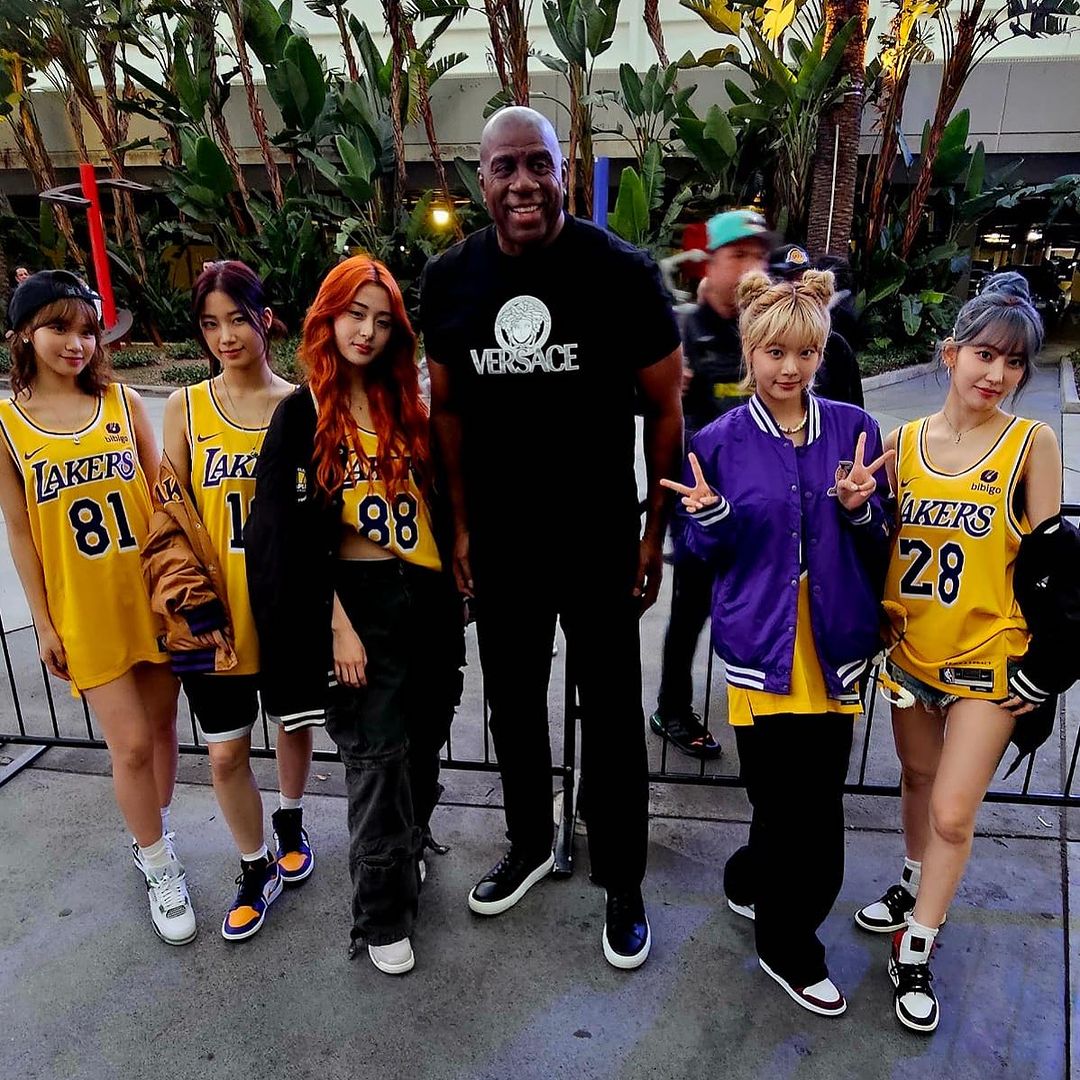 Billionaire Magic Johnson wears a $605 Versace t-shirt to a Lakers game and takes a picture with the K-pop band 'Le Sserafim'