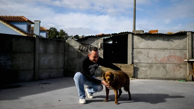 Leonel Costa và chó cưng Bobi tại ngôi nhà ở làng Conqueiros, miền nam Bồ Đào Nha hồi tháng 2. Ảnh: AFP