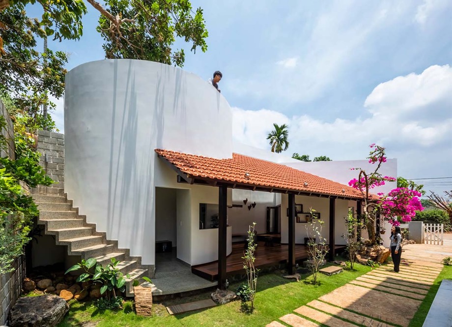 The house has a wide veranda and a raised platform.