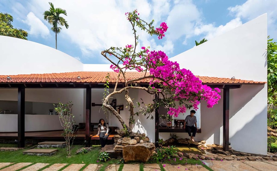 The house has a wide veranda and a raised platform.