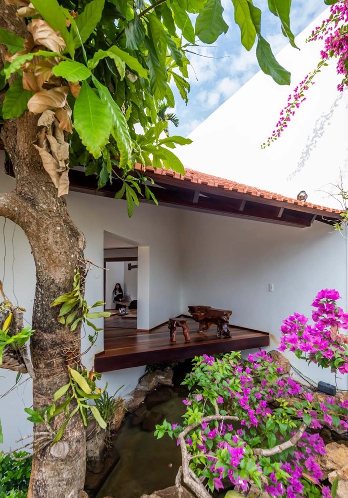 The house has a wide veranda and a raised platform.