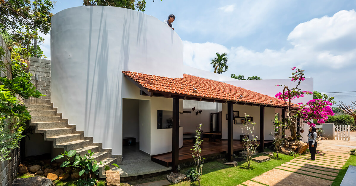 The house has a wide veranda and a raised platform.