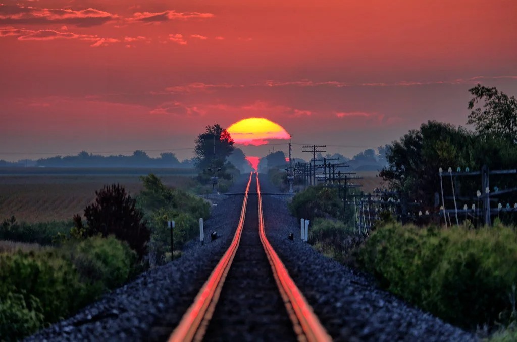 Witness the annual miracle as the sun’s mesmerizing reflection dances upon the railroad tracks, inviting you to capture a photograph that encapsulates the enchantment of this fleeting moment in time.vouyen