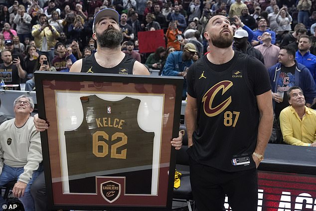 Jason and Travis looked up at the screen as it displayed a tribute video for the Eagles great