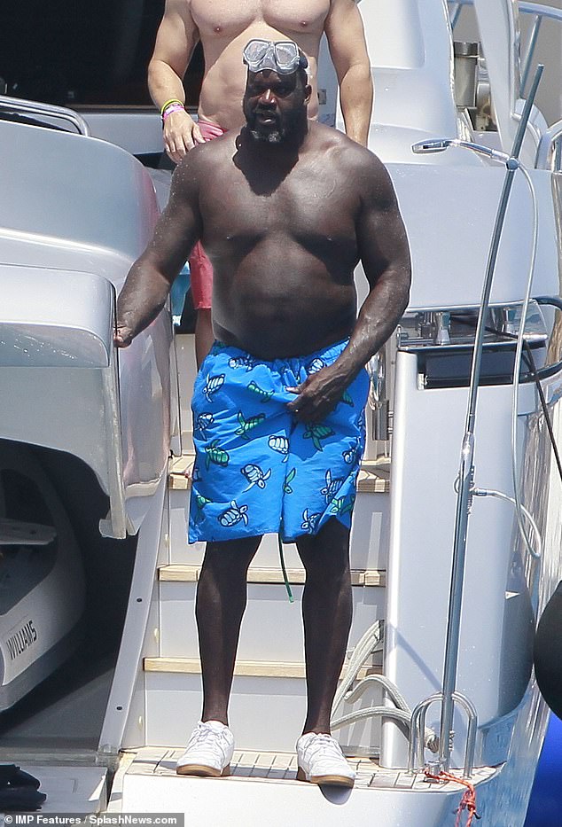 Iconic: Shaquille O'Neal took a break from his busy schedule as he soaked up the sun on a yacht in Formentera, Spain on Wednesday, surrounded by friends and a female friend secret