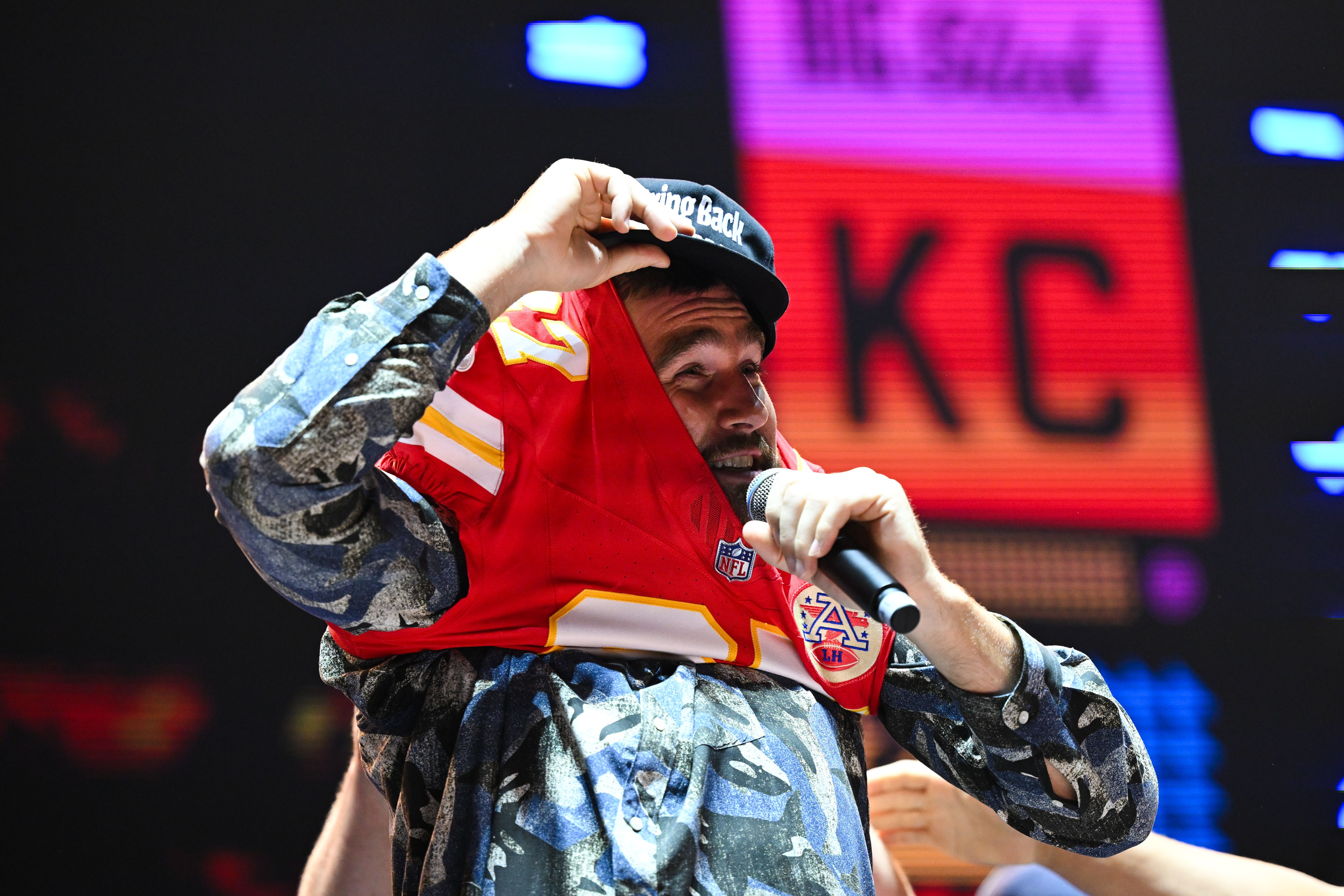 Travis Kelce putting on a jersey