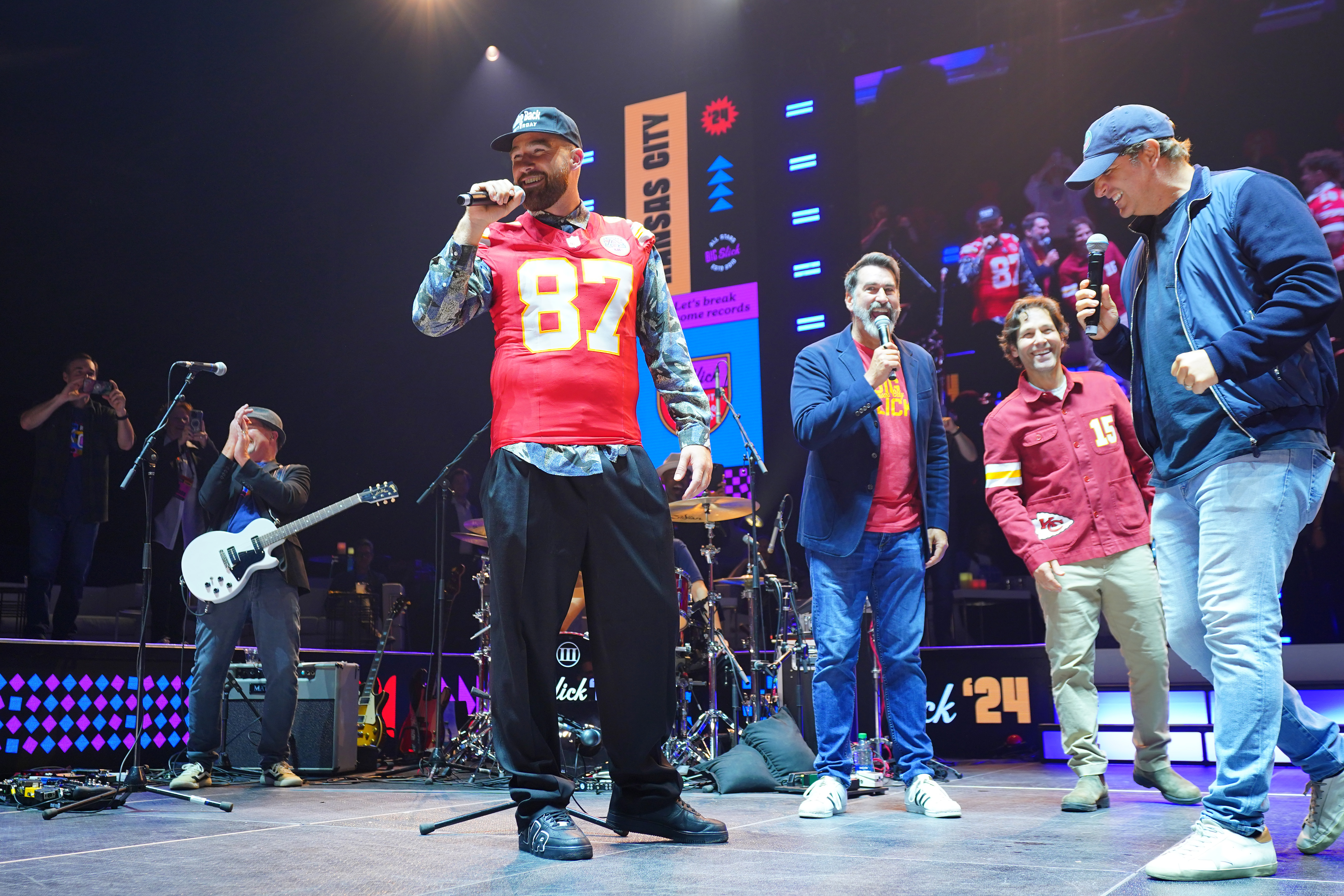 Travis Kelce on stage with Rob Riggle, Paul Rudd, and Peter Schrager